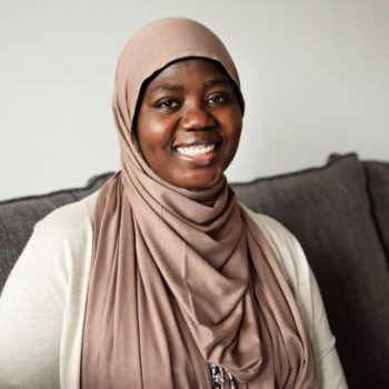 Muslim black woman portrait at home in living-room. She is from African descent living in North America. This is part of a series. Horizontal waist up indoors with copy space. This was taken in Montreal, Quebec, Canada.